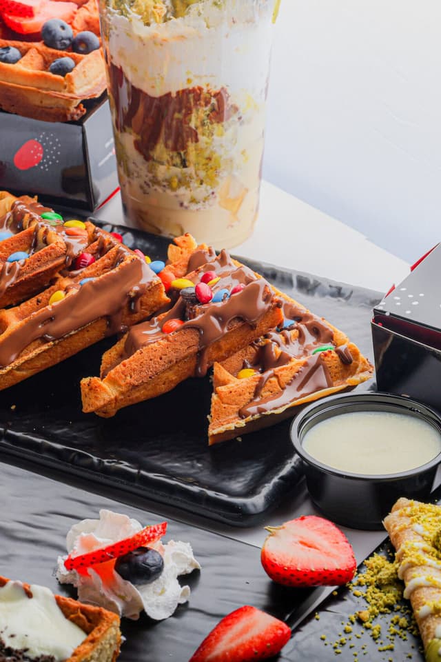A Papa Chocolate waffle board with chocolate and toppings